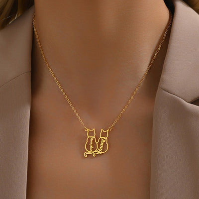 Gold necklace with a cat-shaped pendant on a person wearing a beige blazer.
