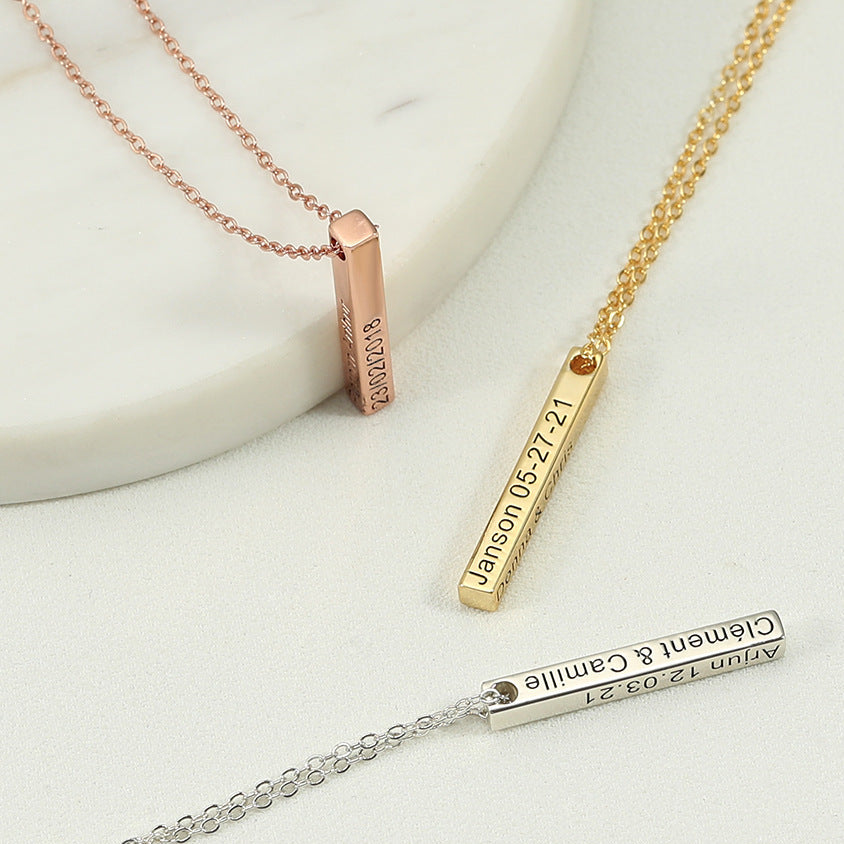 Three gold necklaces with engraved names and dates on a light background