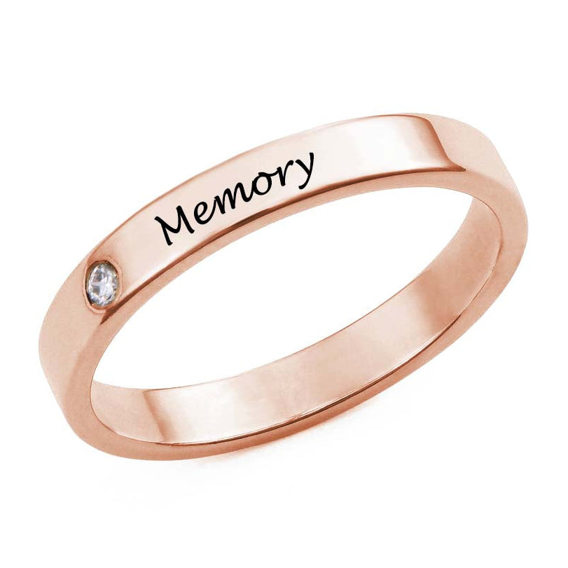 Rose gold ring with 'Memory' engraving on a white background