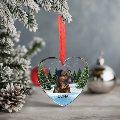Heart-shaped glass ornament featuring a photo of a dog, surrounded by a winter forest scene, ideal as a pet memorial keepsake