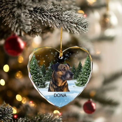 Heart-shaped glass ornament featuring a photo of a dog, surrounded by a winter forest scene, ideal as a pet memorial keepsake