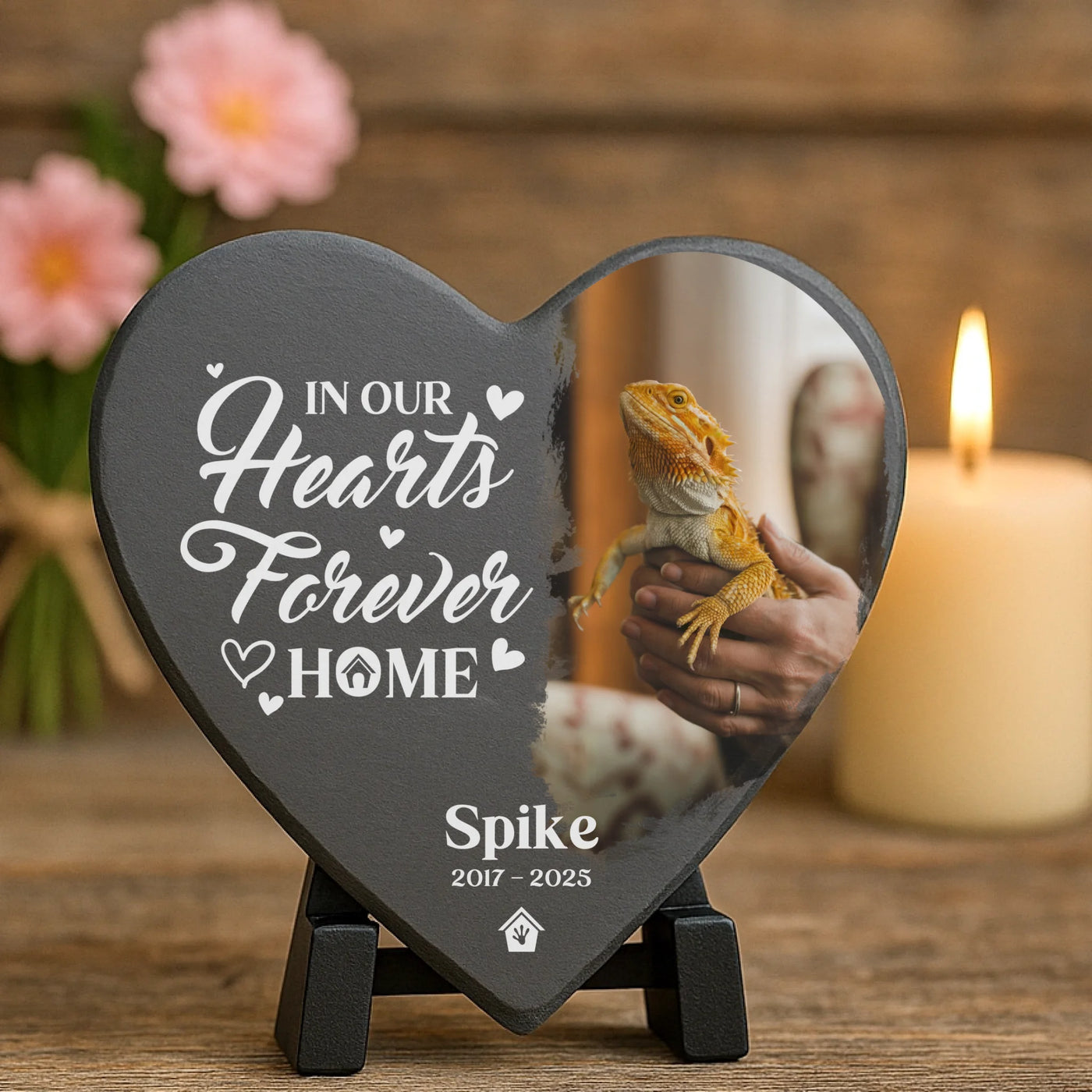 Custom reptile tribute plaque on a stand, with a photo of bearded dragon Spike and memorial quote, placed beside a candle and soft pink flowers.
