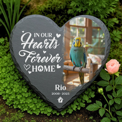 Custom engraved heart-shaped slate memorial for parakeet Rio, with engraved quote “I’ll miss you for the rest of mine,” surrounded by flowers and greenery.