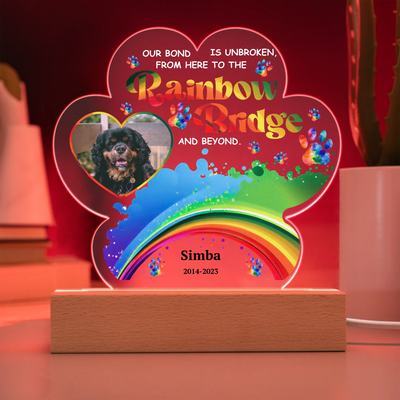 Paw-shaped acrylic LED light featuring a pet photo and the text "Our Bond Is Unbroken from Here to the Rainbow Bridge," perfect as a heartfelt pet memorial