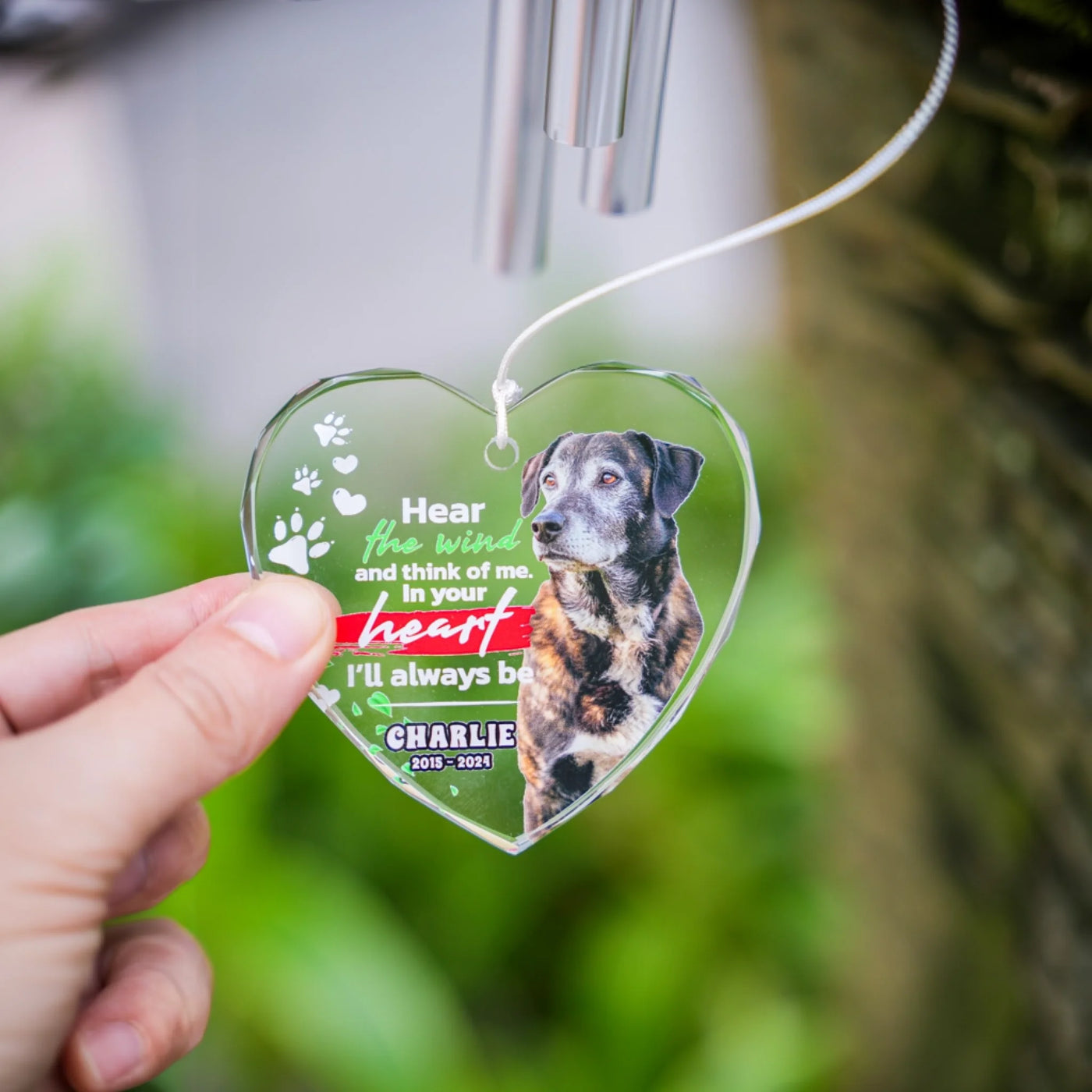 Hand holding heart-shaped glass wind chime with custom pet image, showing size and beveled glass edges