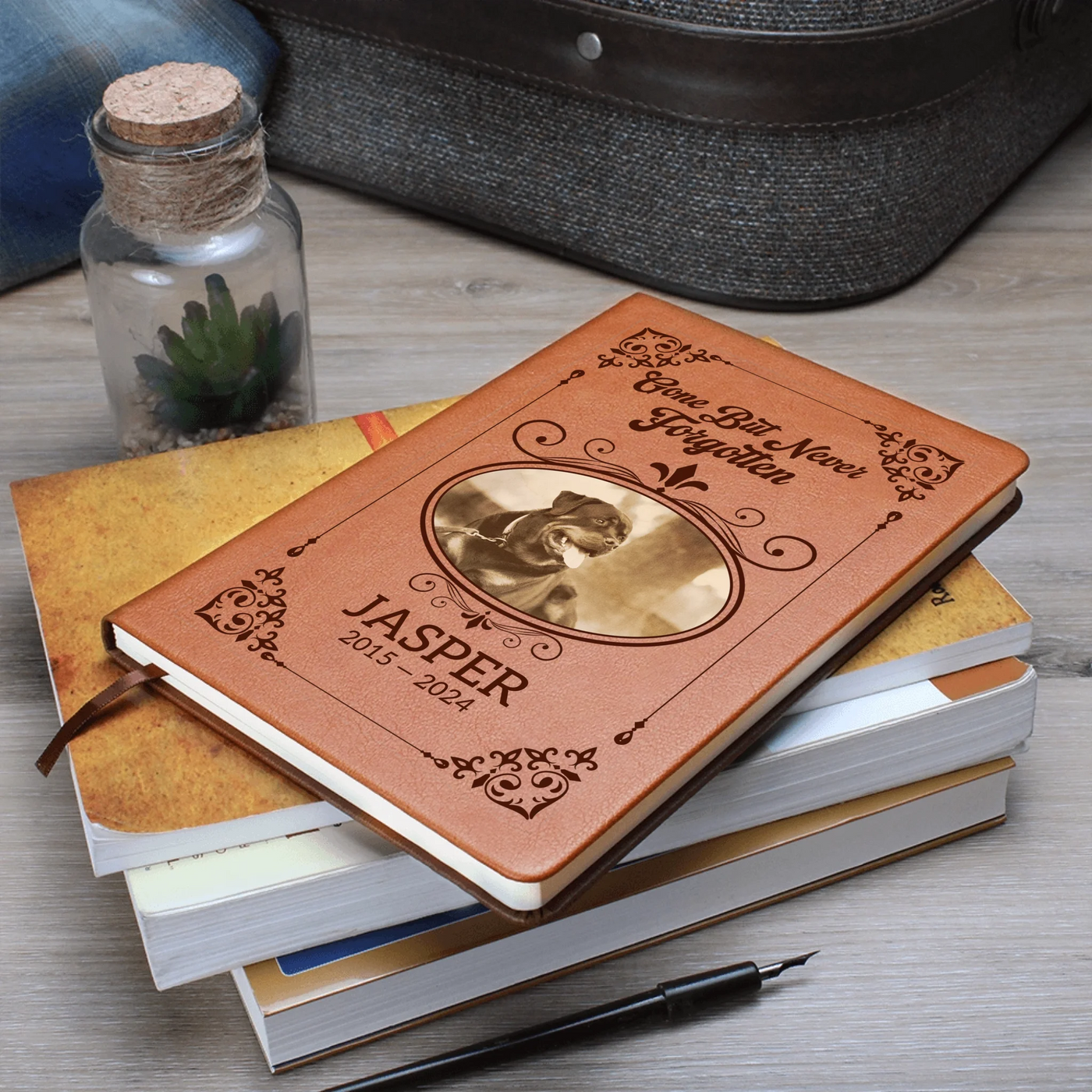 Stacked personalized pet memorial journal on desk, vegan-leather cover with vintage frame design