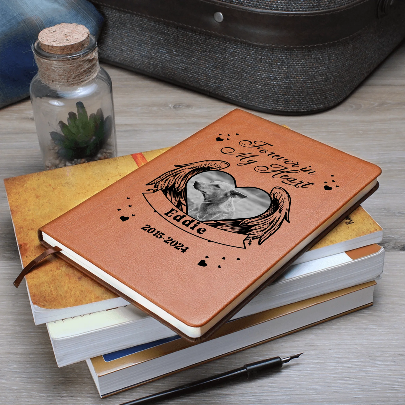 Stack of personalized pet memorial journals with winged heart photo design on cover