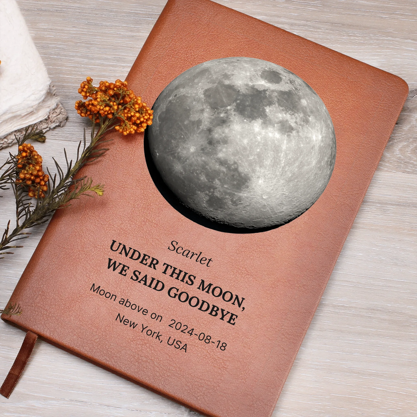 Personalized moon-phase vegan-leather journal on desk — title ‘Under this moon, we said goodbye,’ custom date and location