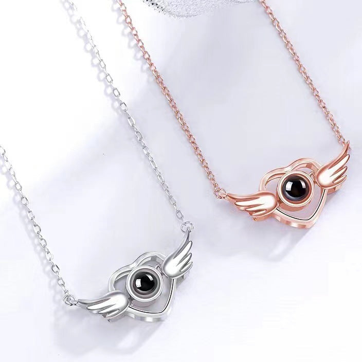 Two necklaces with winged eye pendants in silver and rose gold on a white background