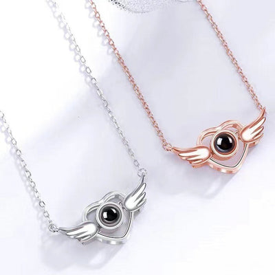Two necklaces with winged eye pendants in silver and rose gold on a white background