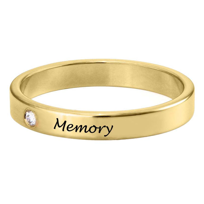 Gold ring with 'Memory' engraving and a small diamond on a white background
