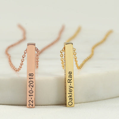 Two gold necklaces with engraved names and dates on a white background