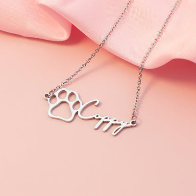 Necklace with paw print and dog name  pendant on a pink background