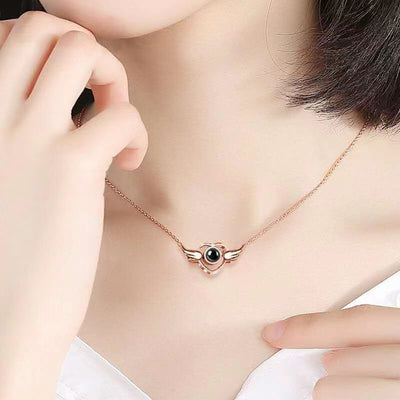 Rose gold necklace with a black pendant worn by a person