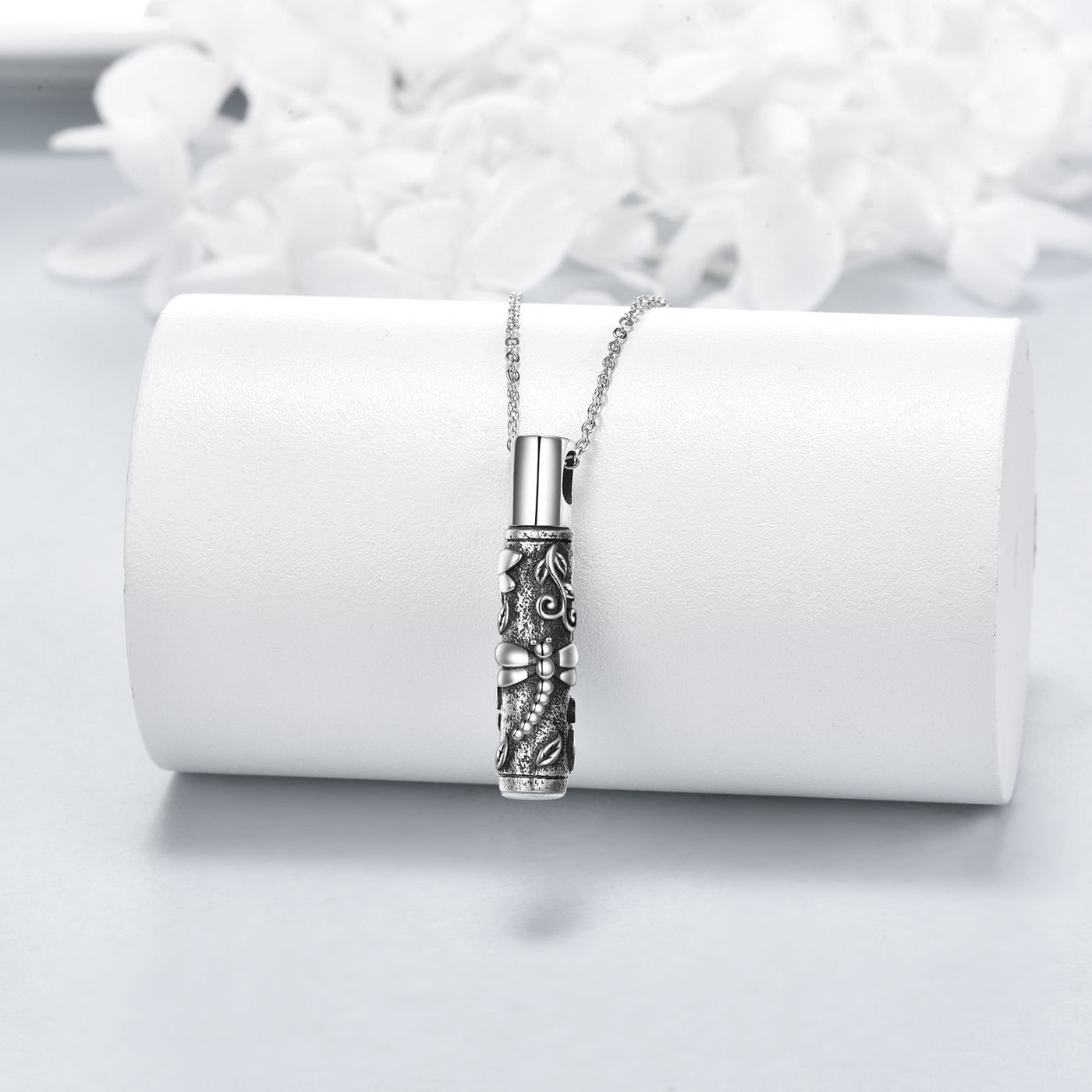 Silver necklace with intricate design on a white surface