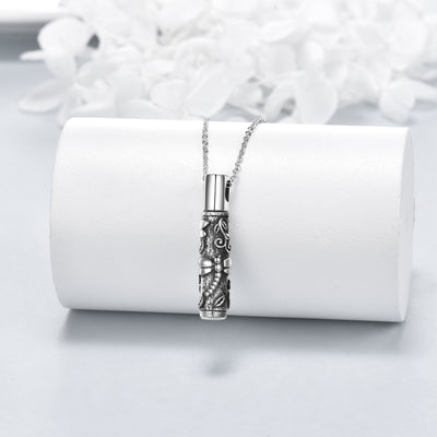 Silver necklace with intricate design on a white surface