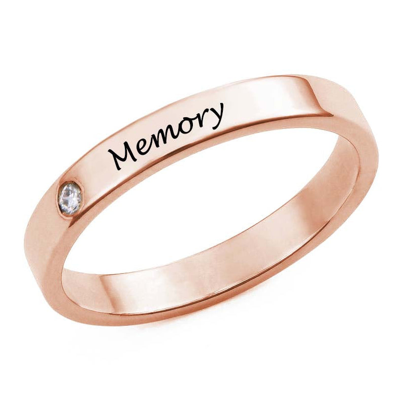 Rose gold ring with 'Memory' engraving on a white background