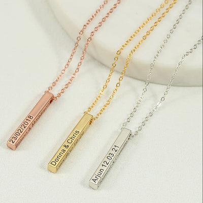 Three necklaces with engraved bars on a light background