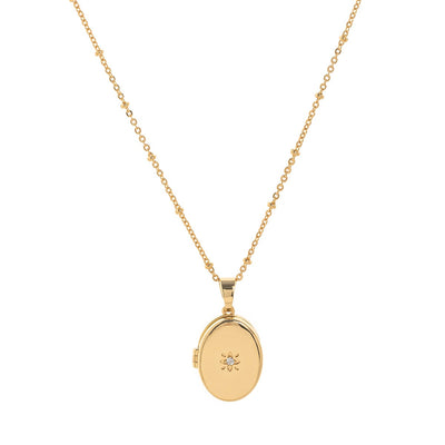 Gold necklace with an oval  pendant on a white background