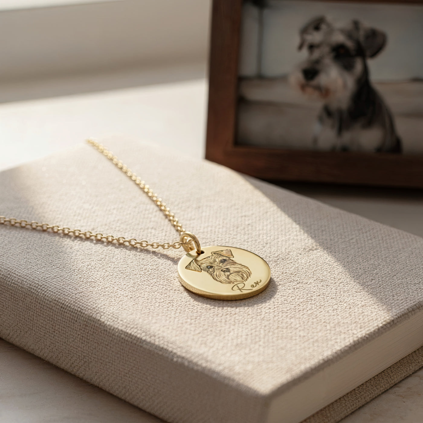 Gold necklace with a dog pendant on a textured surface with a blurred background