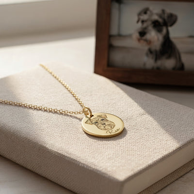 Gold necklace with a dog pendant on a textured surface with a blurred background