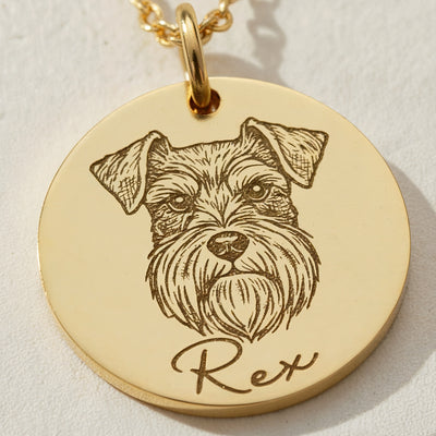 Gold pendant with engraved dog illustration and 'Rex' text on a light background